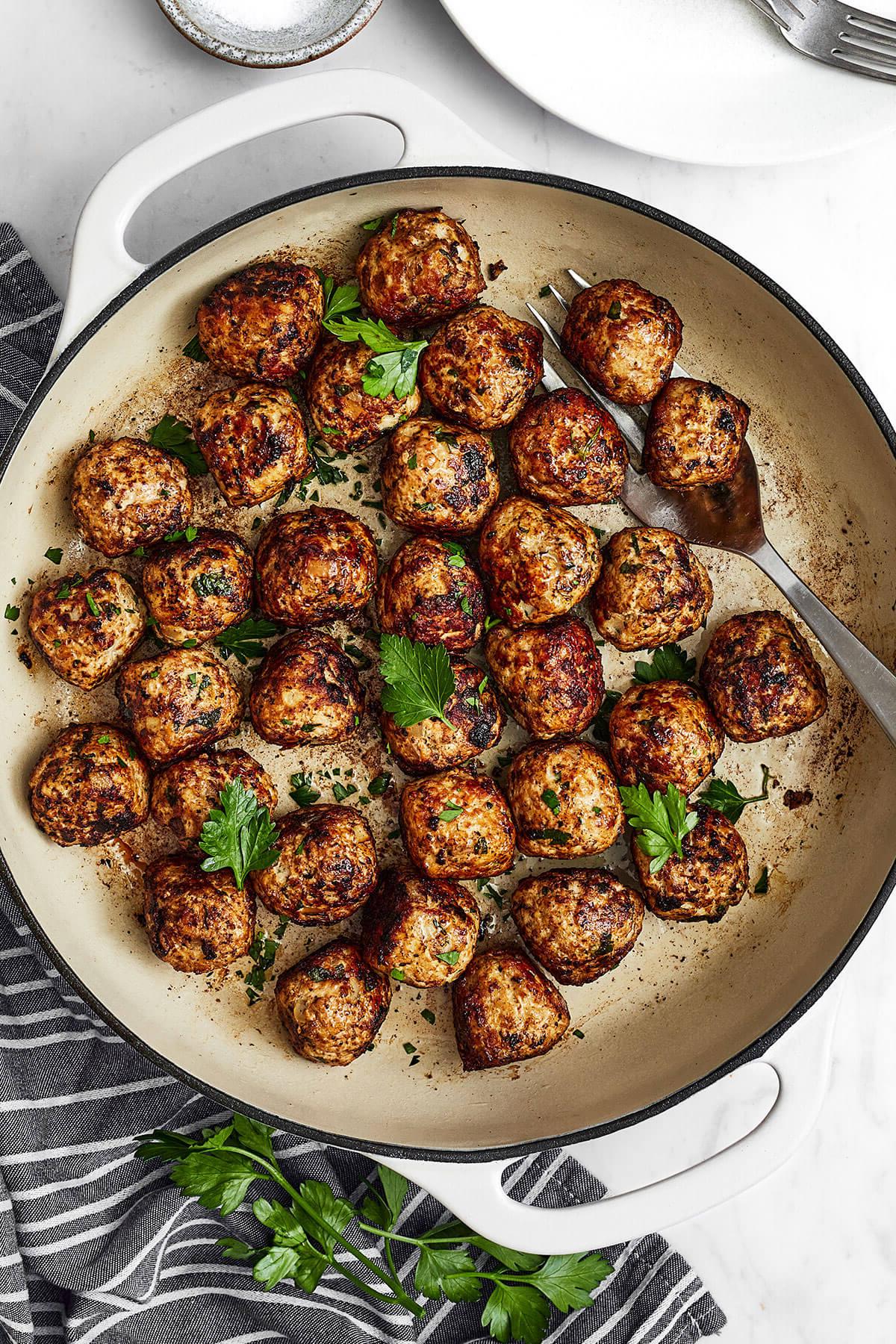 Die 60+ besten Mittelmeer-Diät-Rezepte 71 Eine weiße Pfanne mit Fenchel-Schweinefleischbällchen neben einer Serviette
