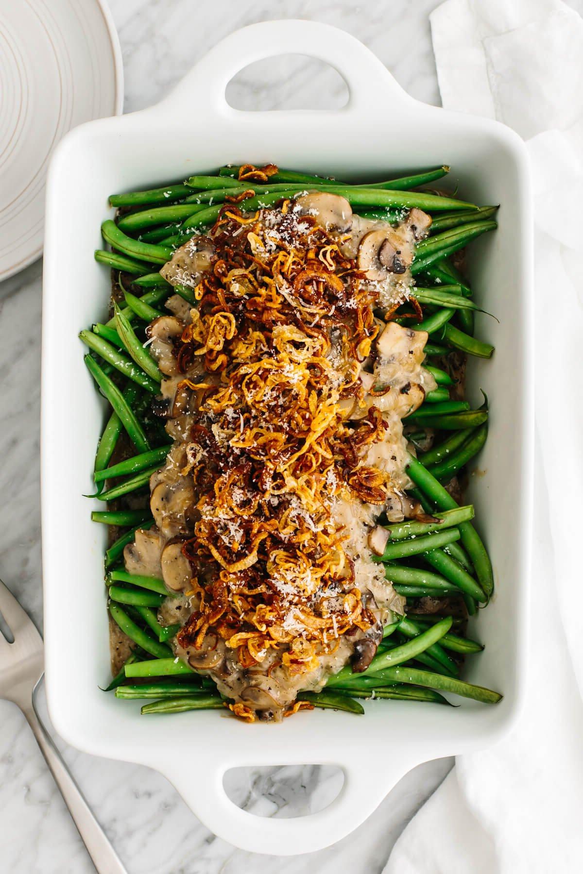 Dieses Thanksgiving-Menü bietet herbstliche Aromen, klassische Gerichte mit modernem Dreh und natürlich den ultimativen gebratenen Truthahn, den die ganze Familie lieben wird! Eine weiße Schale mit Green Bean Casserole.