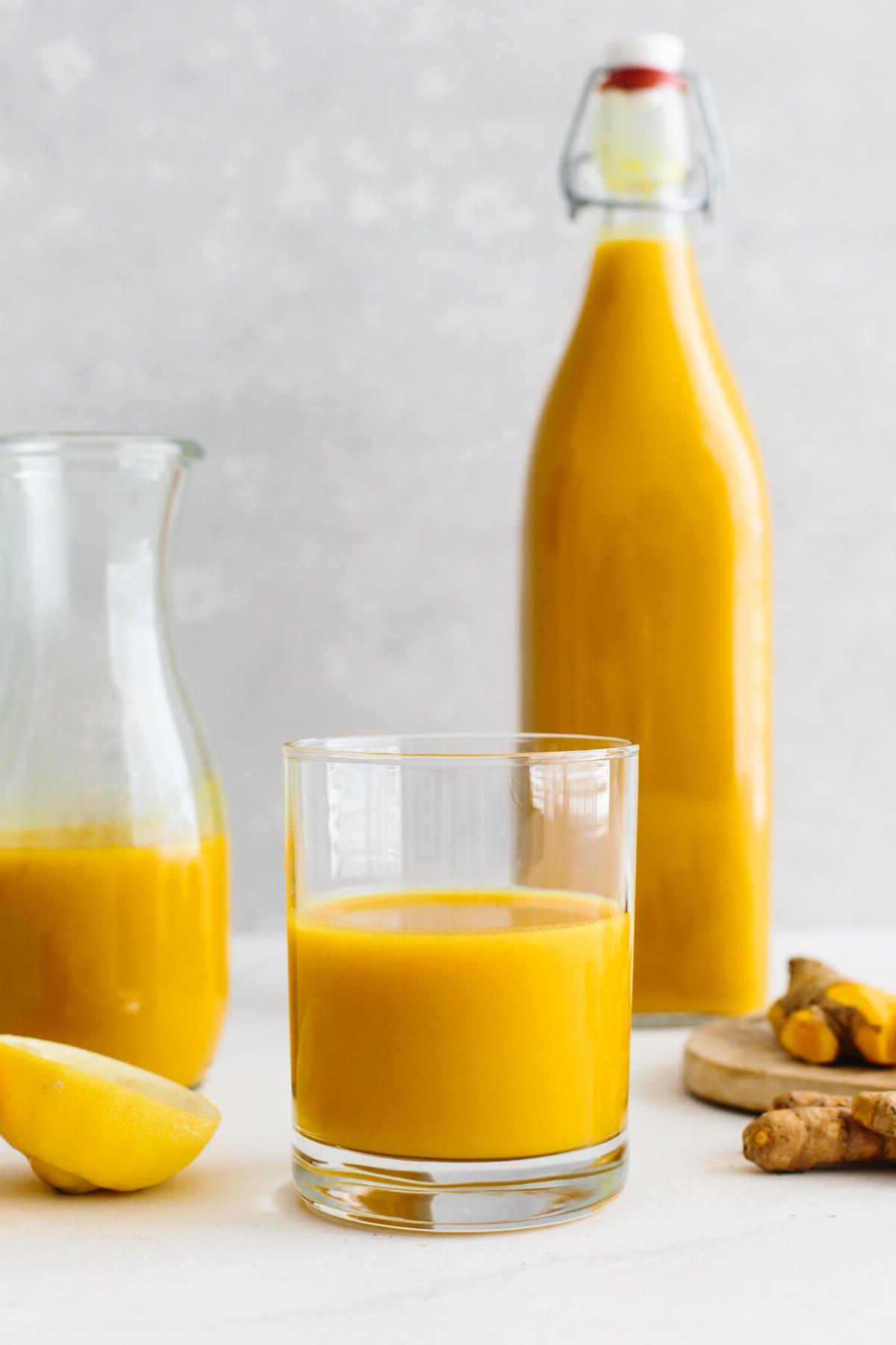 10+ Entzündungshemmende Getränke für mehr Wohlbefinden 9 Jamu-Saft in ein Glas gegossen.