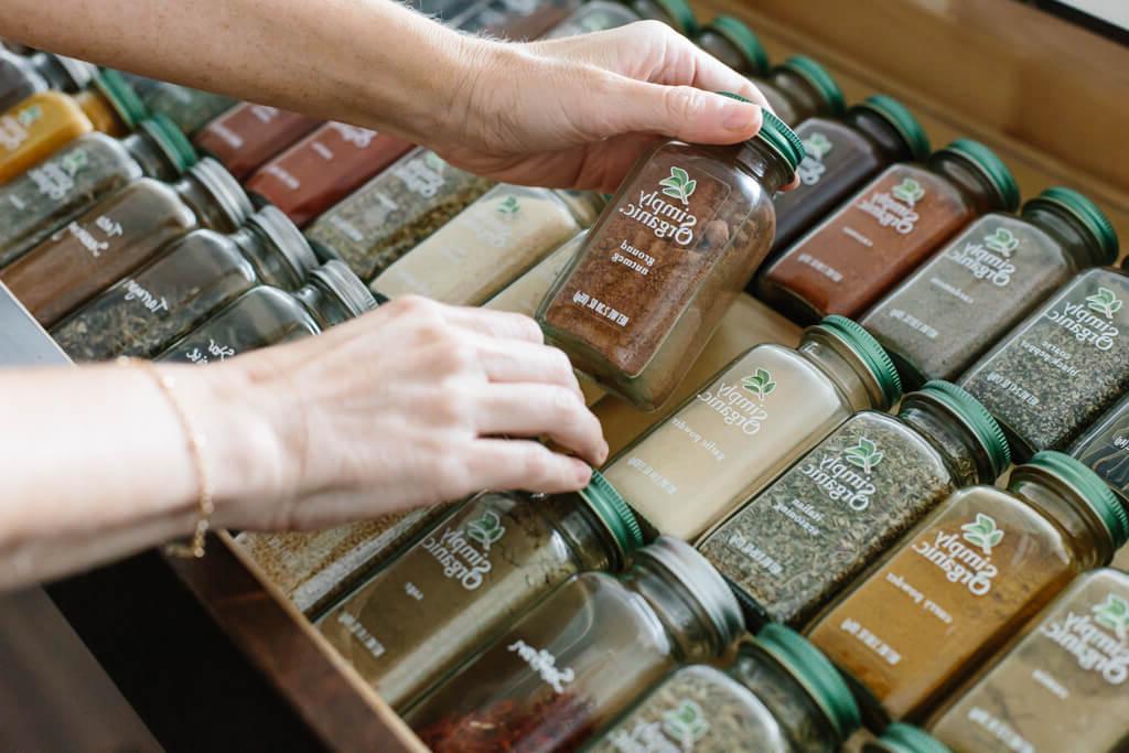 Eine Nahaufnahme von mehreren Gewürzgläsern in einer Gewürzschublade, die die ästhetische Anordnung und die klare Sicht auf die verschiedenen Simply Organic Gewürze hervorhebt. #Küchenästhetik #Gewürzvielfalt #MinimalistischeKüche