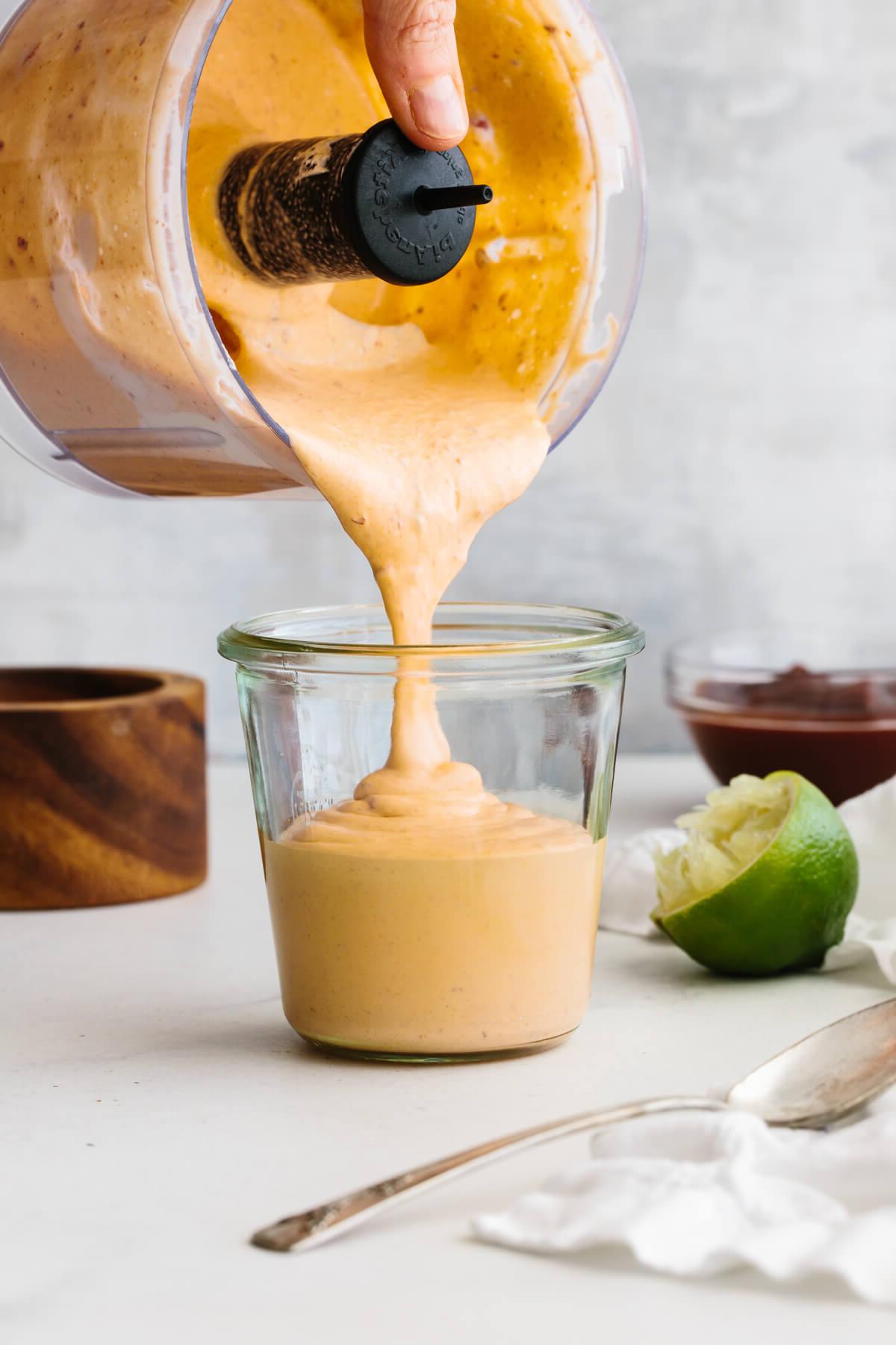30+ Mexikanische Rezepte – Perfekt für den Cinco de Mayo 9 Chipotle-Soße aus der Küchenmaschine in ein Glasgefäß gießen.