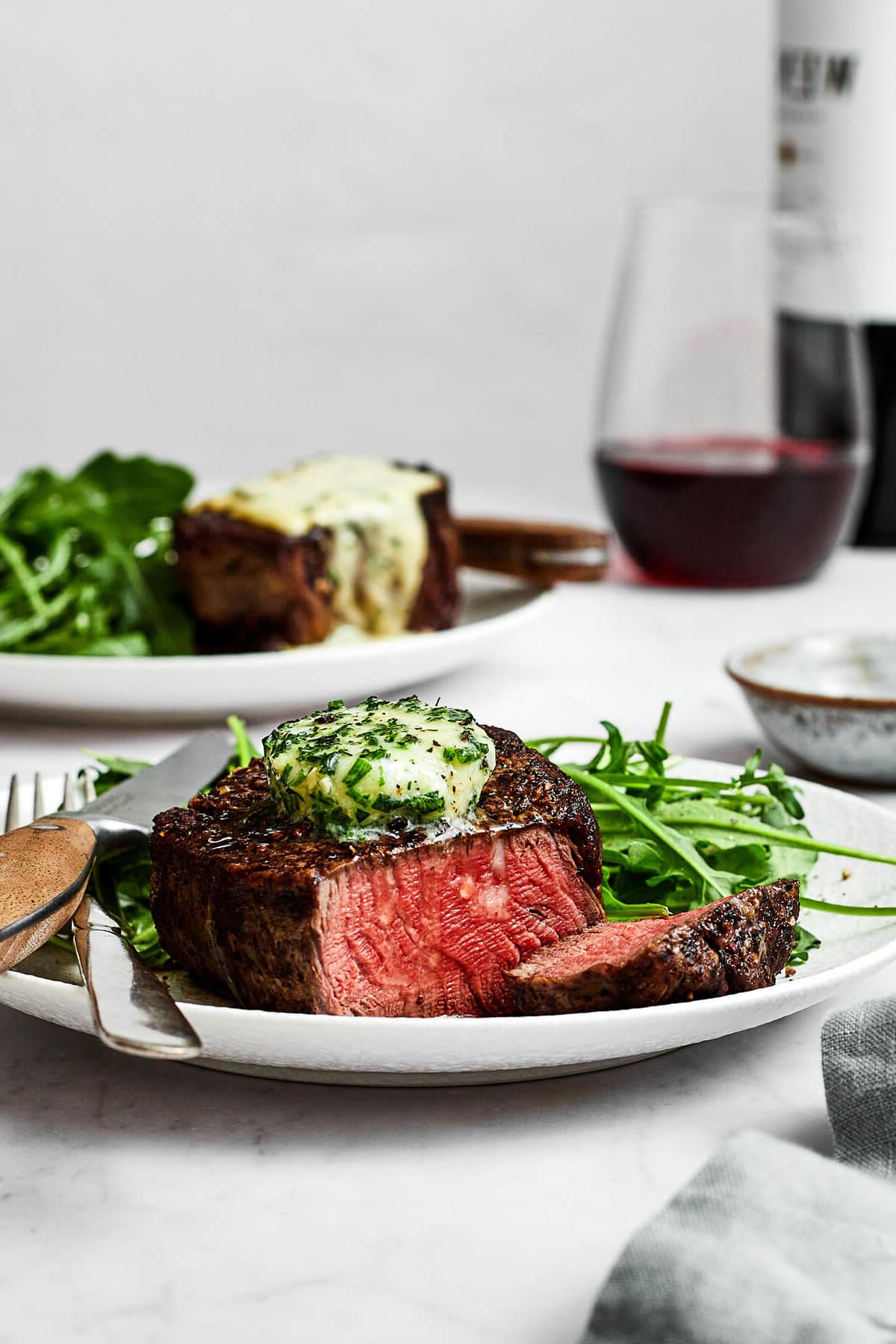 Top 10 Rezepte 2023 10 Ein Teller Filet Mignon neben einem Glas Wein und einem Besteckset