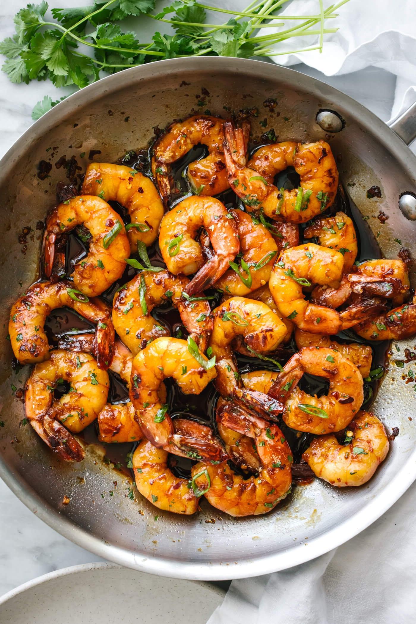 10+ beste Garnelenrezepte 10 Honig-Knoblauch-Garnelen in einer Metallpfanne neben Koriander.