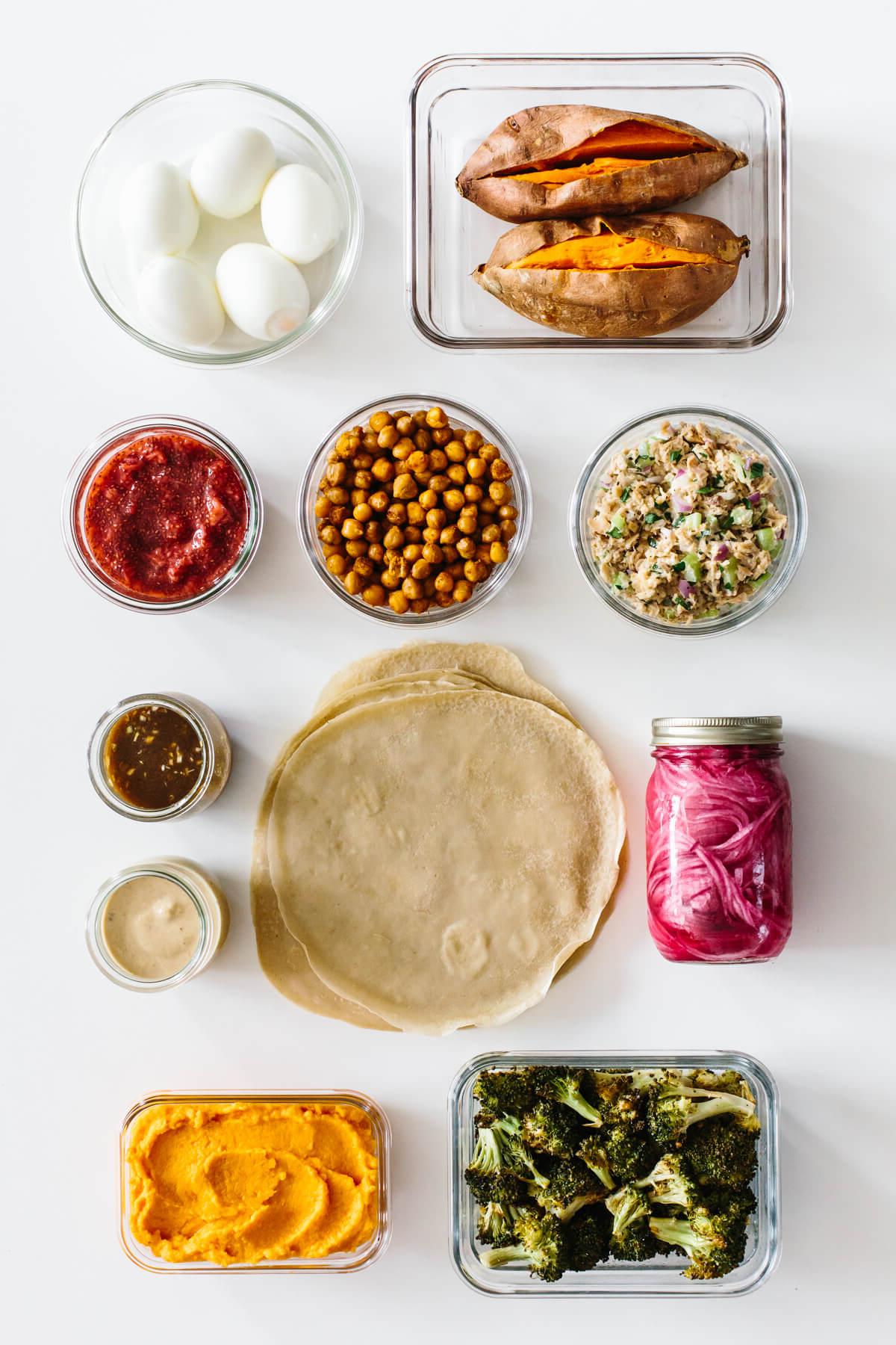 Dieses preiswerte Meal Prep zeigt, dass gesunde Ernährung nicht teuer sein muss. Verwandeln Sie 11 vorbereitete Zutaten in 7 Mahlzeiten, die jeweils 3€ oder weniger kosten! Zutaten auf einem Tisch für eine budgetfreundliche Mahlzeitenvorbereitung