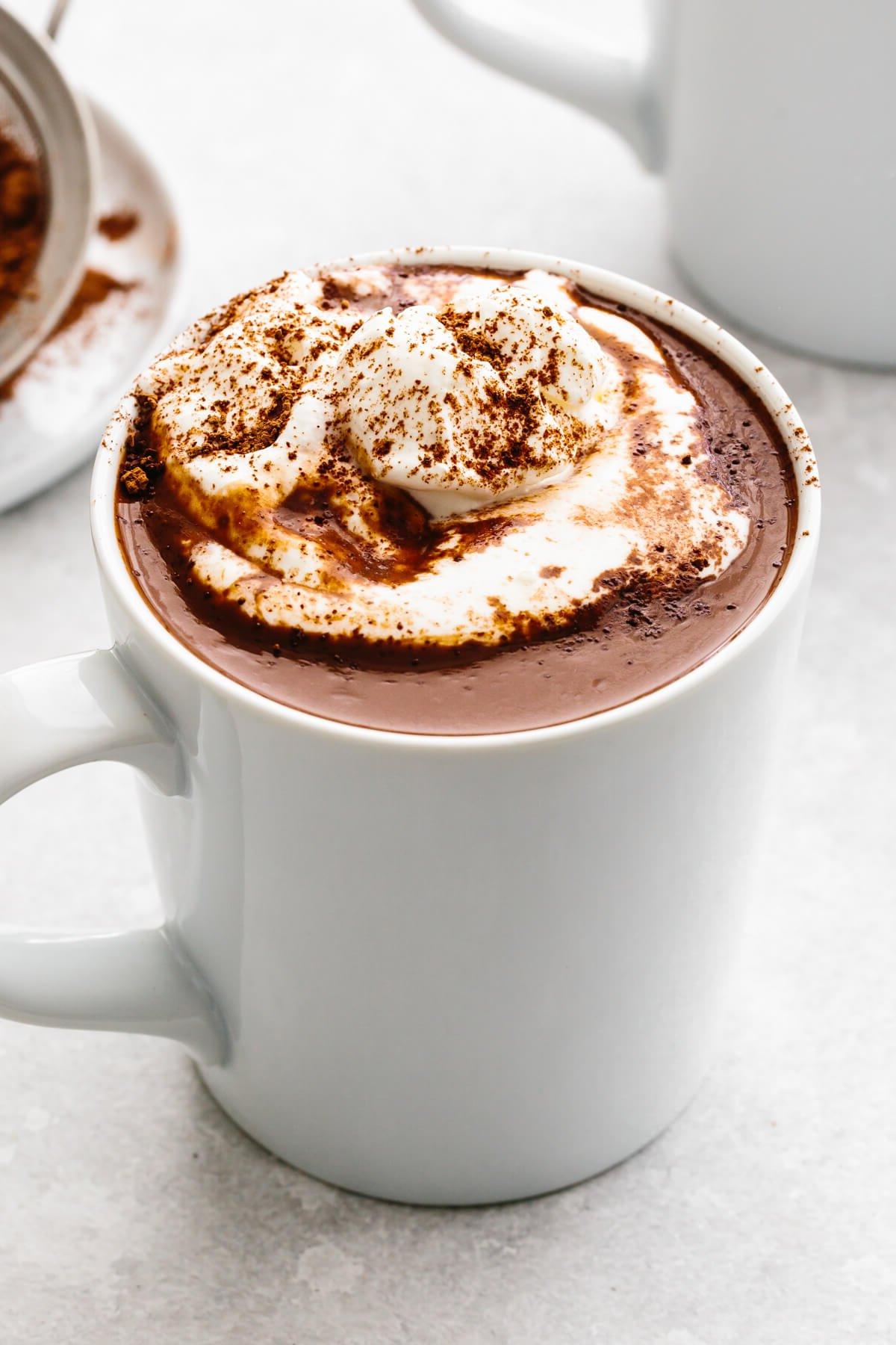 50+ Beste Weihnachtsessen Ideen 21 Eine weiße Tasse heiße Schokolade und Schlagsahne.