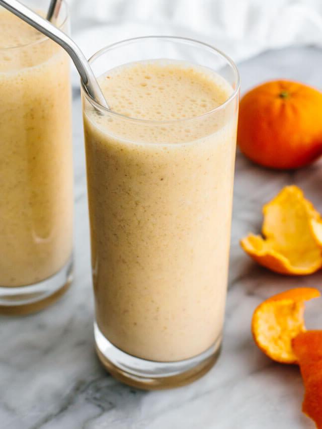 Mandarin-Frühstückssmoothie in einem Glas neben Mandarinen