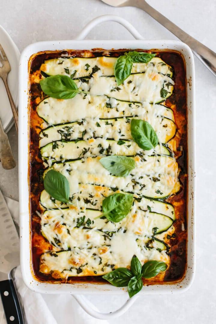 Zucchini-Lasagne in einer weißen Auflaufform.