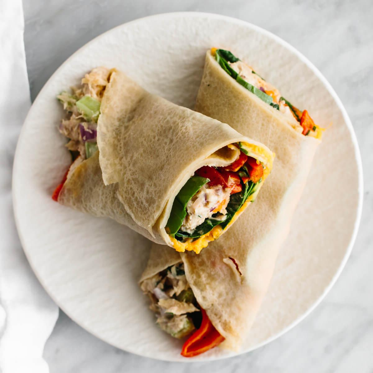 Dieses preiswerte Meal Prep zeigt, dass gesunde Ernährung nicht teuer sein muss. Verwandeln Sie 11 vorbereitete Zutaten in 7 Mahlzeiten, die jeweils 3€ oder weniger kosten! Thunfischsalat-Wrap auf einem Teller für ein budgetfreundliches Meal Prep