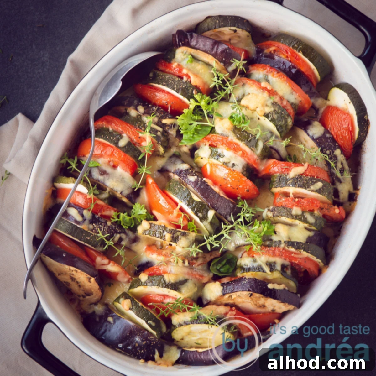 10 Festive Christmas Mains & Sides 7 a square picture of an ovendish filled with roasted slices of vegetables, herbs and cheese gratin.