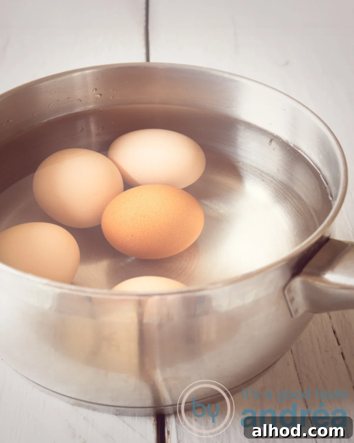 Eggs submerged in cold water in a saucepan, ready for cooking.