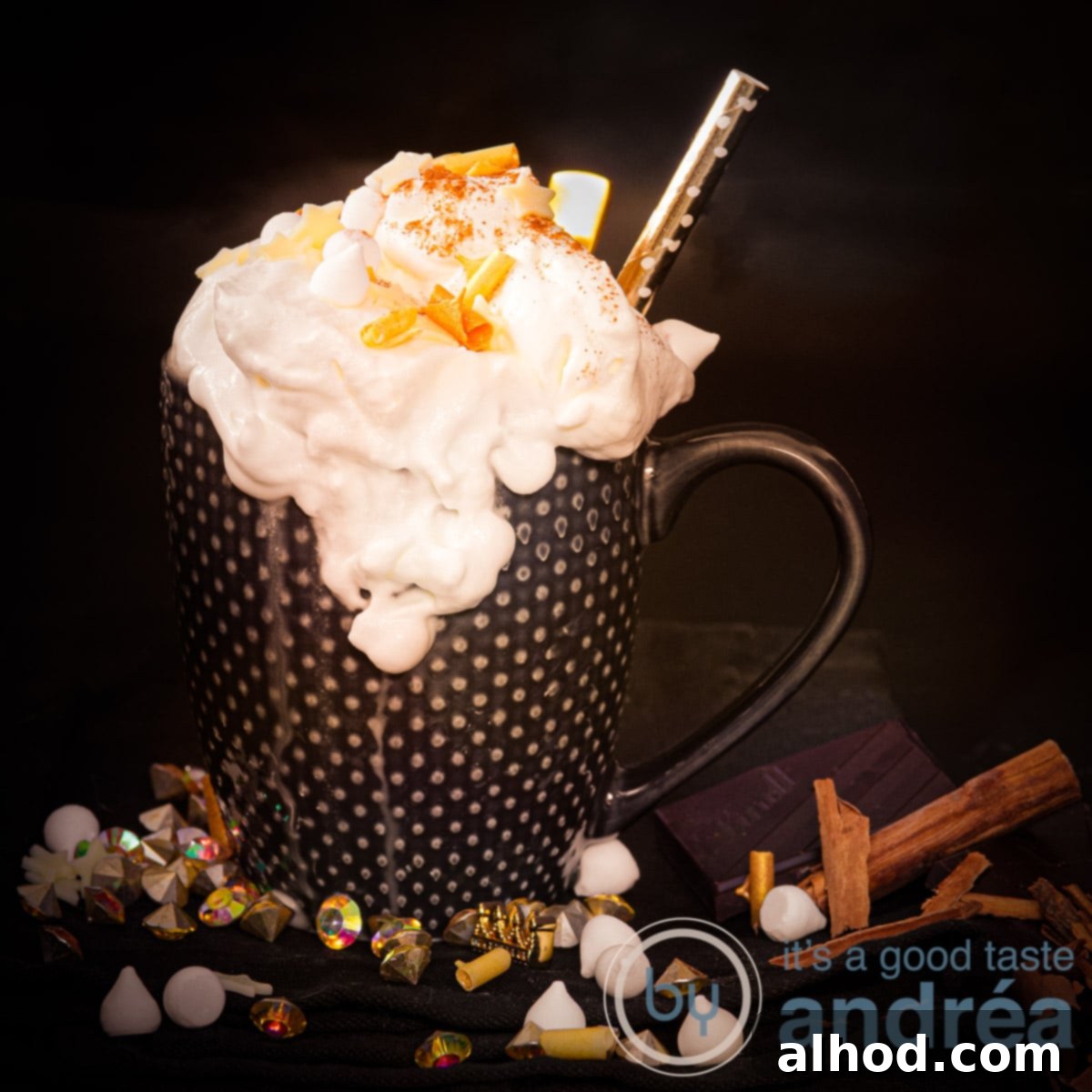 11 Merry & Bright Holiday Sips 7 A square photo of a black mug with whipped cream, golden chocolate curls and cinnamon marshmallows on the black background.