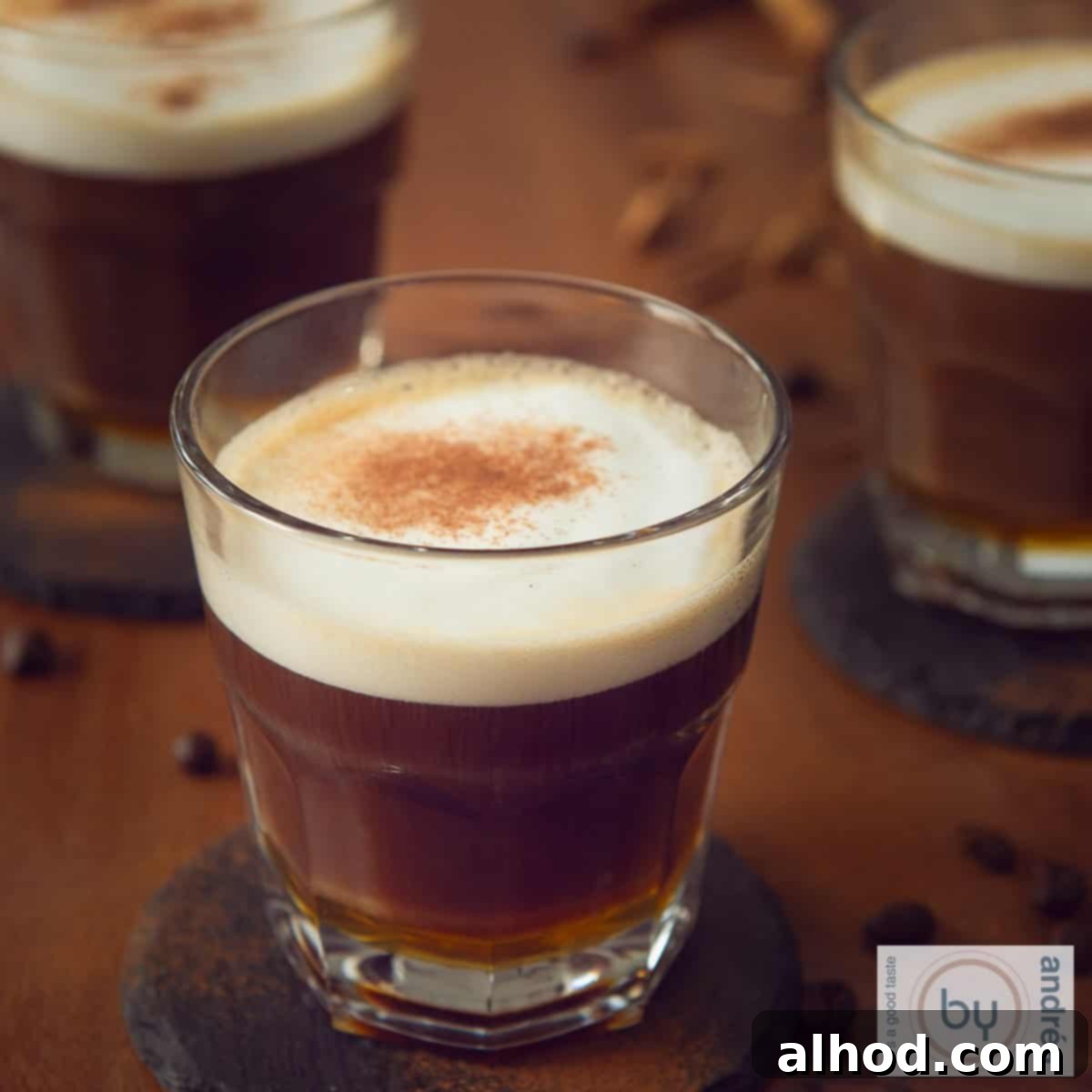 11 Festive Sips to Brighten Your Christmas 10 A square photo with a brown table with three cups of apfelcorn honey cafe au lait poured into it.