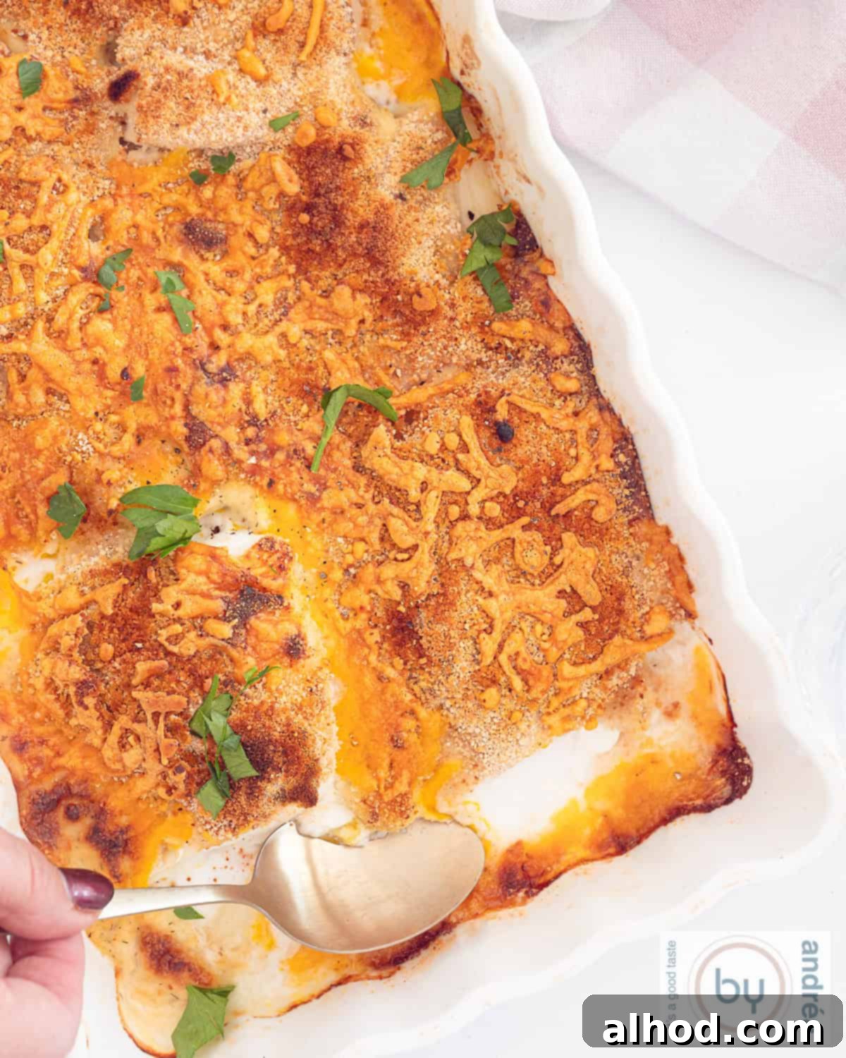 Effortless Cheesy Cod Bake 8 An overhead view of a white casserole dish filled with baked cod, generously covered with a golden-brown cheesy and crispy topping, ready to be served.