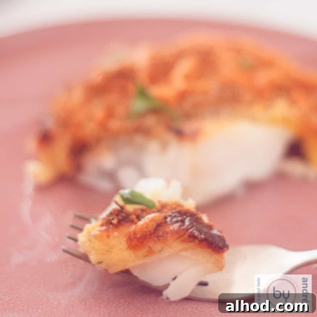 Effortless Cheesy Cod Bake 9 A square picture with cod with a cheese breadcrumb topping. A fork took a bite.