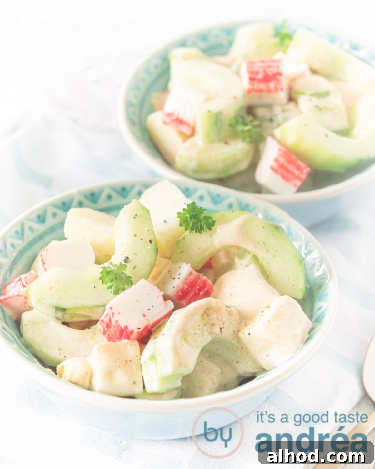Bourbon-Infused Surimi Salad Recipe 2 A bowl of vibrant surimi salad featuring flaked surimi, diced cucumber, apple, and egg, generously topped with a rich, creamy homemade cocktail sauce, ready to be served.