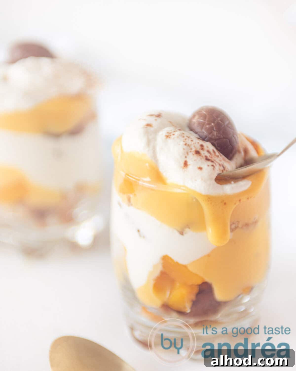 Eggnog Tiramisu with Peaches 2 A spoon taking a bite of creamy tiramisu with cookies, sliced peaches and a drizzle of eggnog, ready for a festive holiday serving.