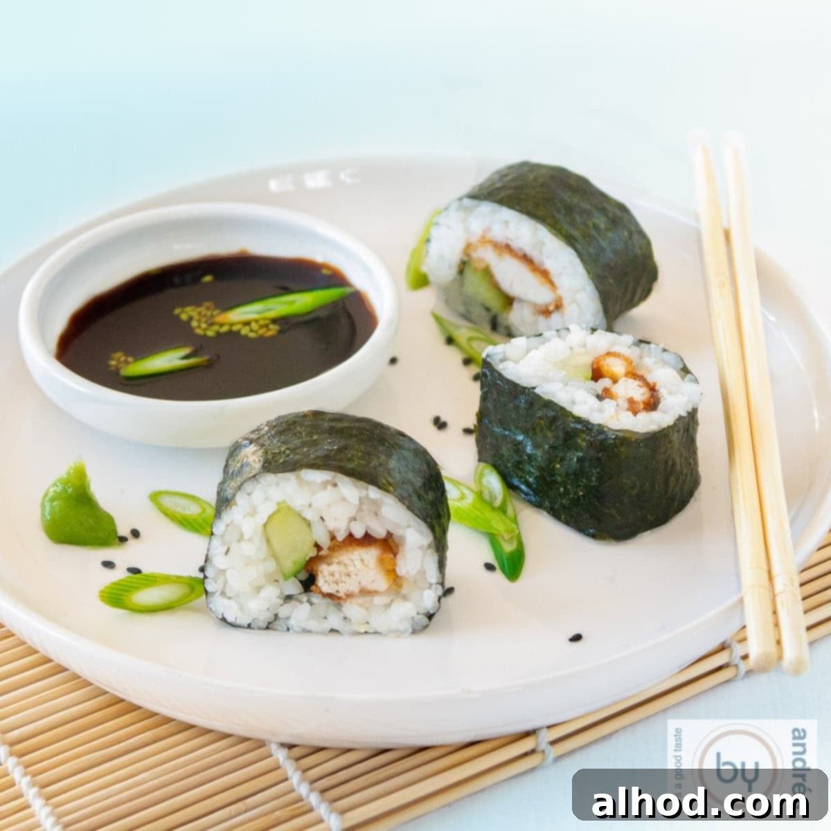 Kentucky Sushi: A Bold New Roll 3 A square photo of 3 rolls of sushi with chicken and cucumber and soy sauce on a white plate.