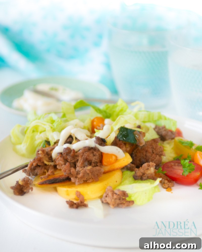 Kapsalon: A Healthy Makeover 2 A delicious and healthy Kapsalon oven dish with crispy potatoes, seasoned ground beef, fresh vegetables, and melted Gouda cheese, topped with iceberg lettuce and garlic sauce.