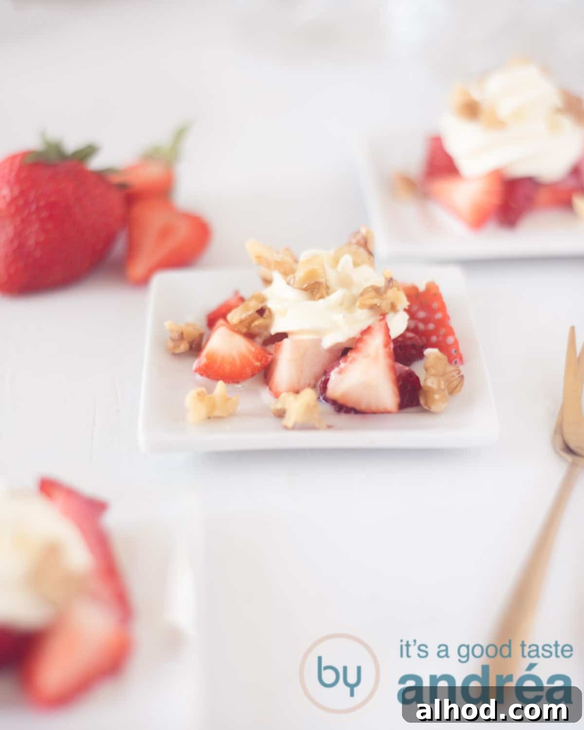 3-Ingredient Strawberry Cream Cheese Dream 2 An elevation photo at an angle of three plates with strawberry cream cheese on a white background. Strawberries at the top left, a golden fork at the bottom right