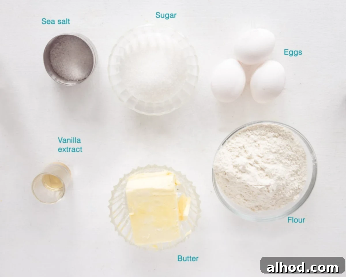 Delicate French Butter Sables 3 A beautifully arranged flat lay of ingredients for French Sable Cookies, with each item individually labelled on a clean white background. Essential components like butter, sugar, flour, egg yolks, salt, and vanilla extract are clearly visible.