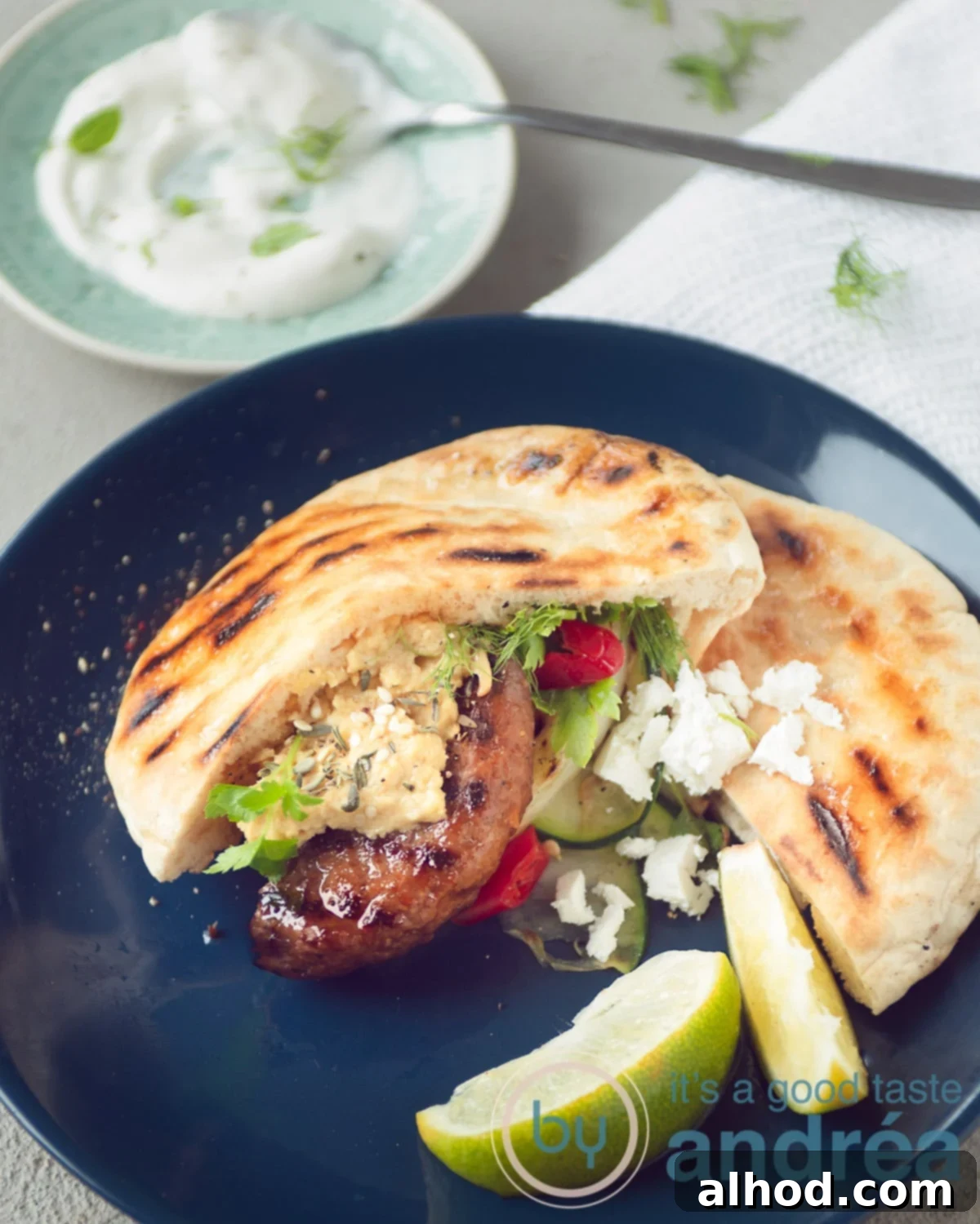 Mediterranean Feta Burgers Made Easy 7 A blue plate with grilled vegetables, hamburger and feta cheese.