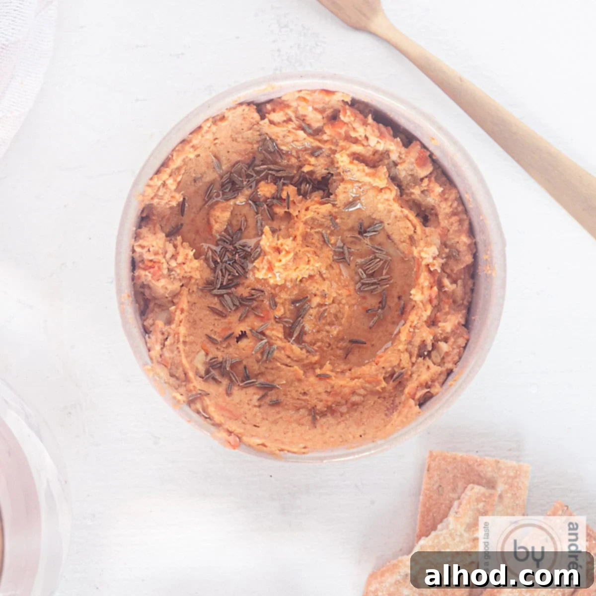 Velvet Sweet Potato Hummus 3 A square picture with a bowl filled with sweet potato and chickpea hummus. Some crackers laying aside