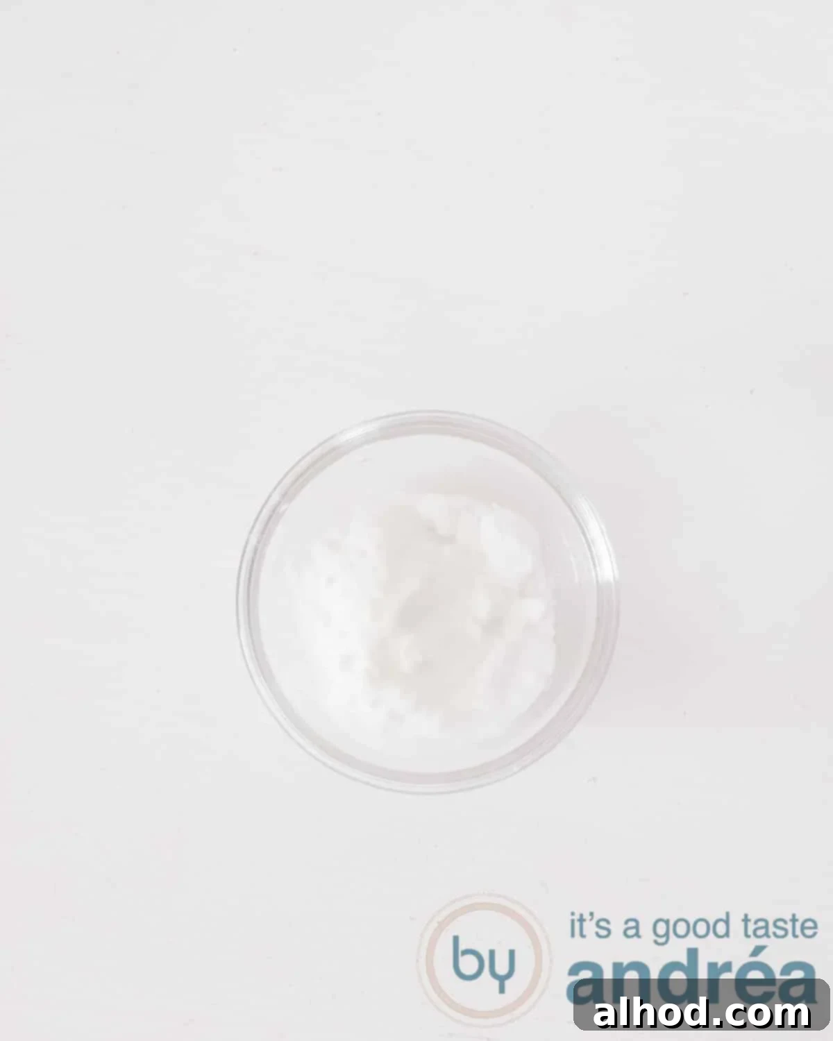 A glass dish with baking soda on a white background
