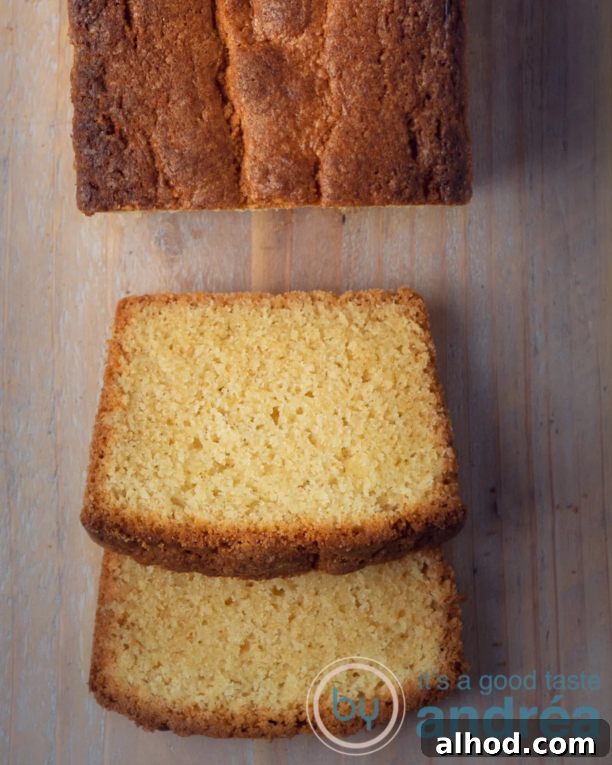Golden Dutch Pound Cake 6 Two slices of a golden-brown Dutch pound cake are neatly arranged on a wooden board, with a portion of the main cake visible at the top, emphasizing its moist texture.