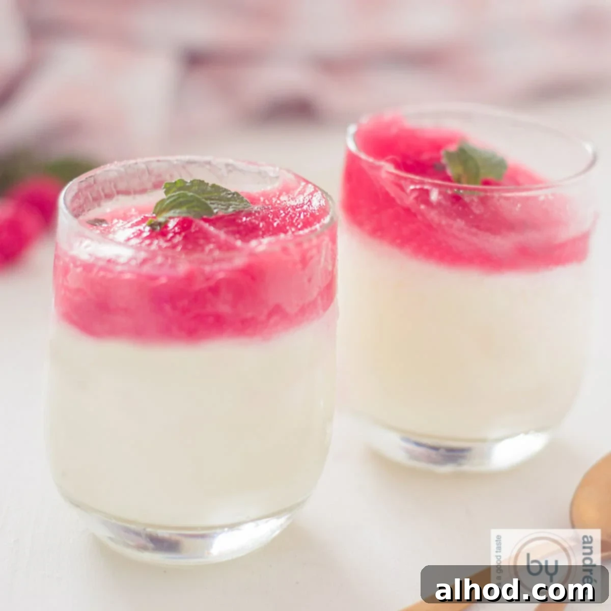 Frosted Lime Yogurt with Raspberry Mint Glaze 4 A square photo of two glasses filled with lime yogurt ice cream with a raspberry and mint glaze. The background is white.
