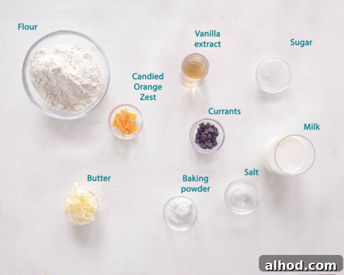 Teatime Bliss Speedy Orange Currant Scones 3 A flat lay image showing all the individual ingredients for Quick Orange-Currant Scones laid out on a white background with descriptive labels.