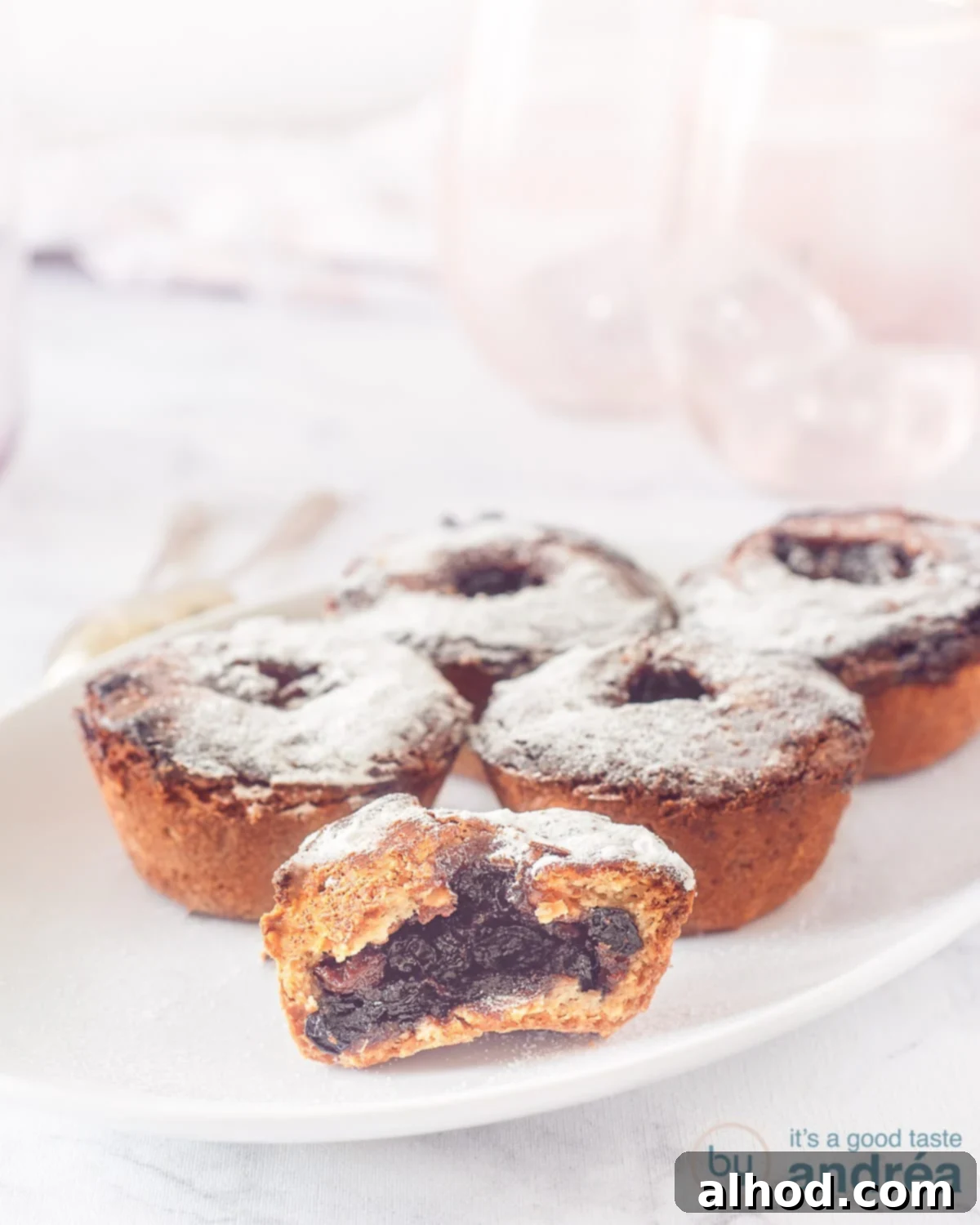 Toasted Hazelnut Mince Pies 2 Five beautifully baked fruit mince pies with a golden hazelnut crust on a pristine white plate, ready for a festive gathering.