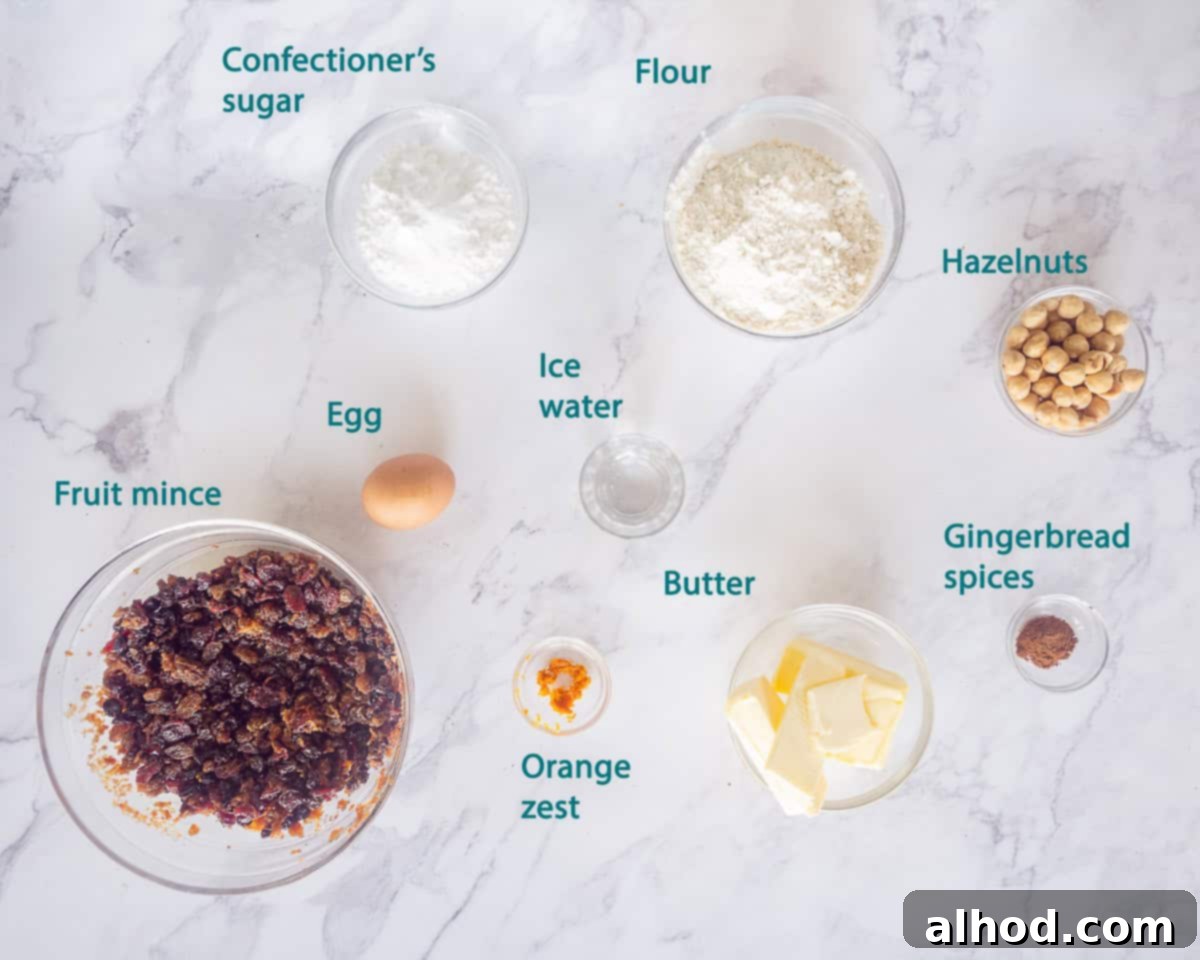 Toasted Hazelnut Mince Pies 4 Ingredients for the hazelnut crust, including flour, ground hazelnuts, butter, and confectioners' sugar, arranged on a white marble surface.
