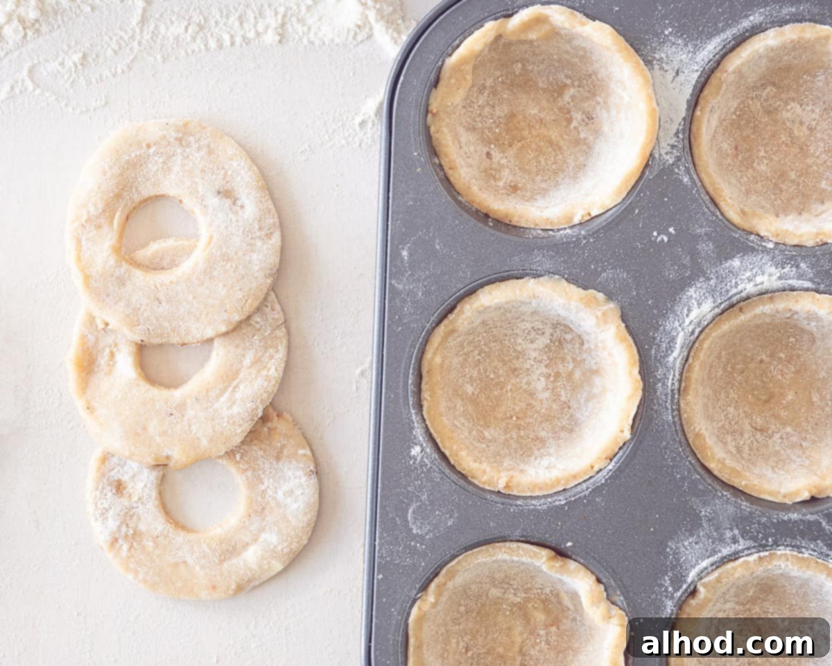 Decadent Hazelnut Mince Pies 7 Cupcake tin with dough bases, some filled with fruit mince, and decorative dough tops prepared on the side.