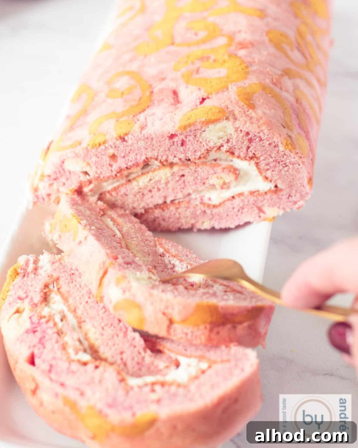 A beautiful rose gold Swiss roll with two slices cut off, revealing the creamy white filling. A golden fork is taking a bite from a slice, emphasizing its soft texture.