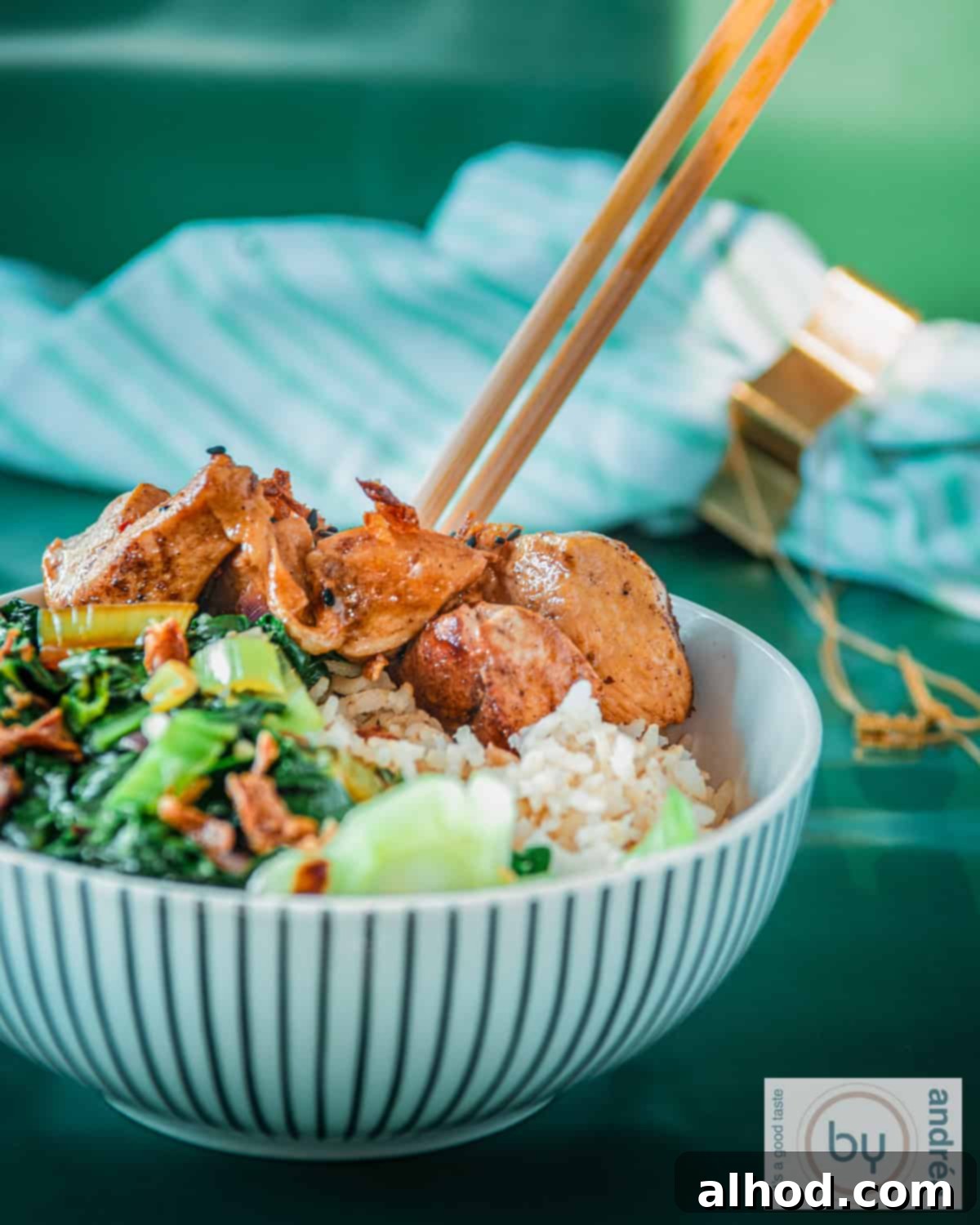 Rapid Soy Chicken with Zesty Lemon Rice and Crisp Bok Choy 2 A bowl filled with rice, bok choy, and chicken with ketjap sauce. A green background.