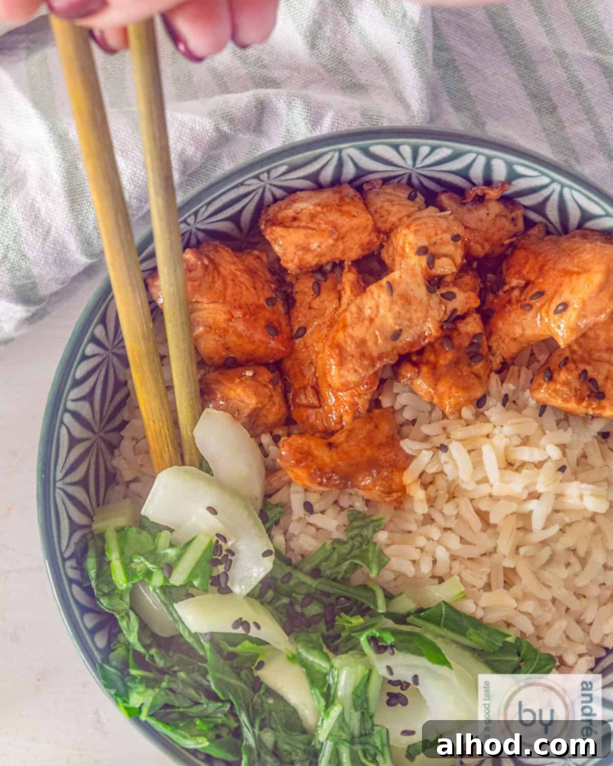 Rapid Soy Chicken with Zesty Lemon Rice and Crisp Bok Choy 3 An overhead photo of a bowl of sticky ketjap chicken, bok choy, and lemon rice. Two chopsticks are in the bowl.