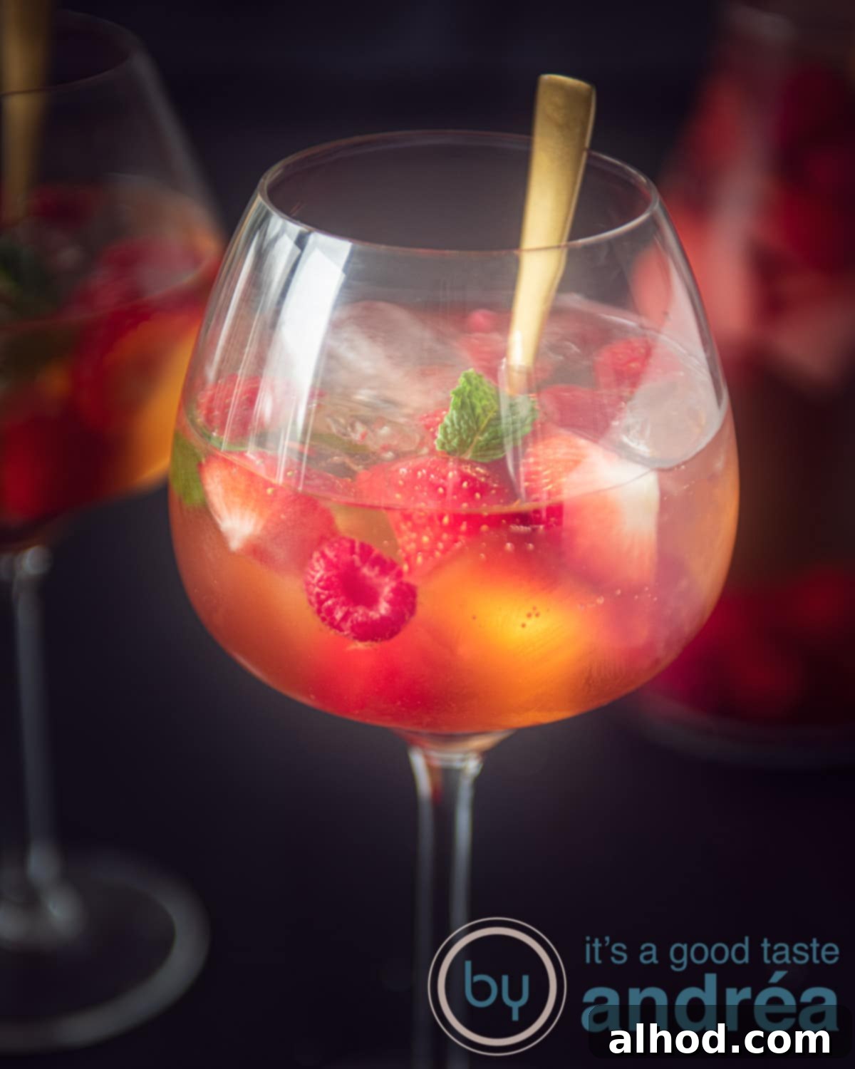 Sangria's Secret Ingredient: Licor 43 2 A glass filled with white sangria 43 on a black background. A jar and another glass are in the background
