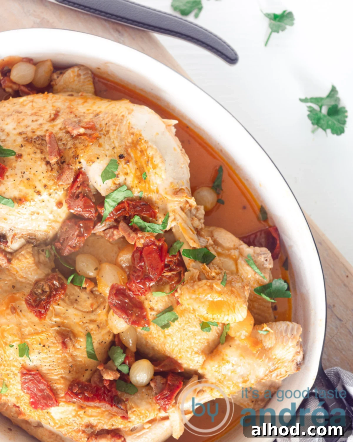 Coq au Vin Blanc 2 a casserole with coq au vin blanc, bacon and tomatoes