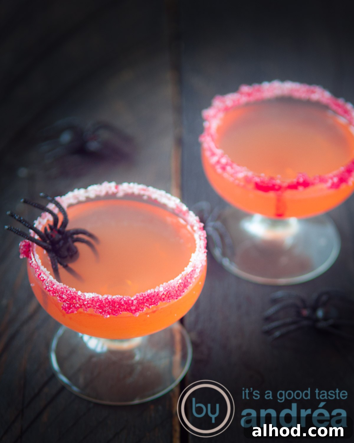 two Halloween cocktails with Passoa, Malibu and Orange juice and some spiders across the picture