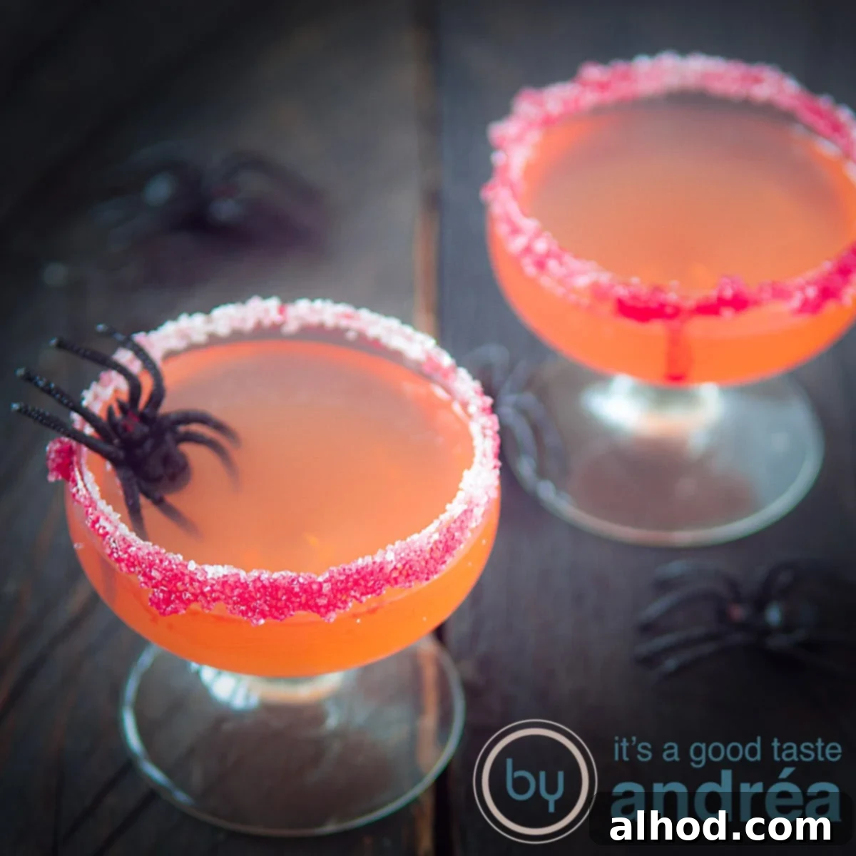 Spooky Cosmopolitan Cocktail 3 Een vierkante foto met twee glazen gevuld met Halloween cosmpolitan cocktail. Een rode suikerrand.