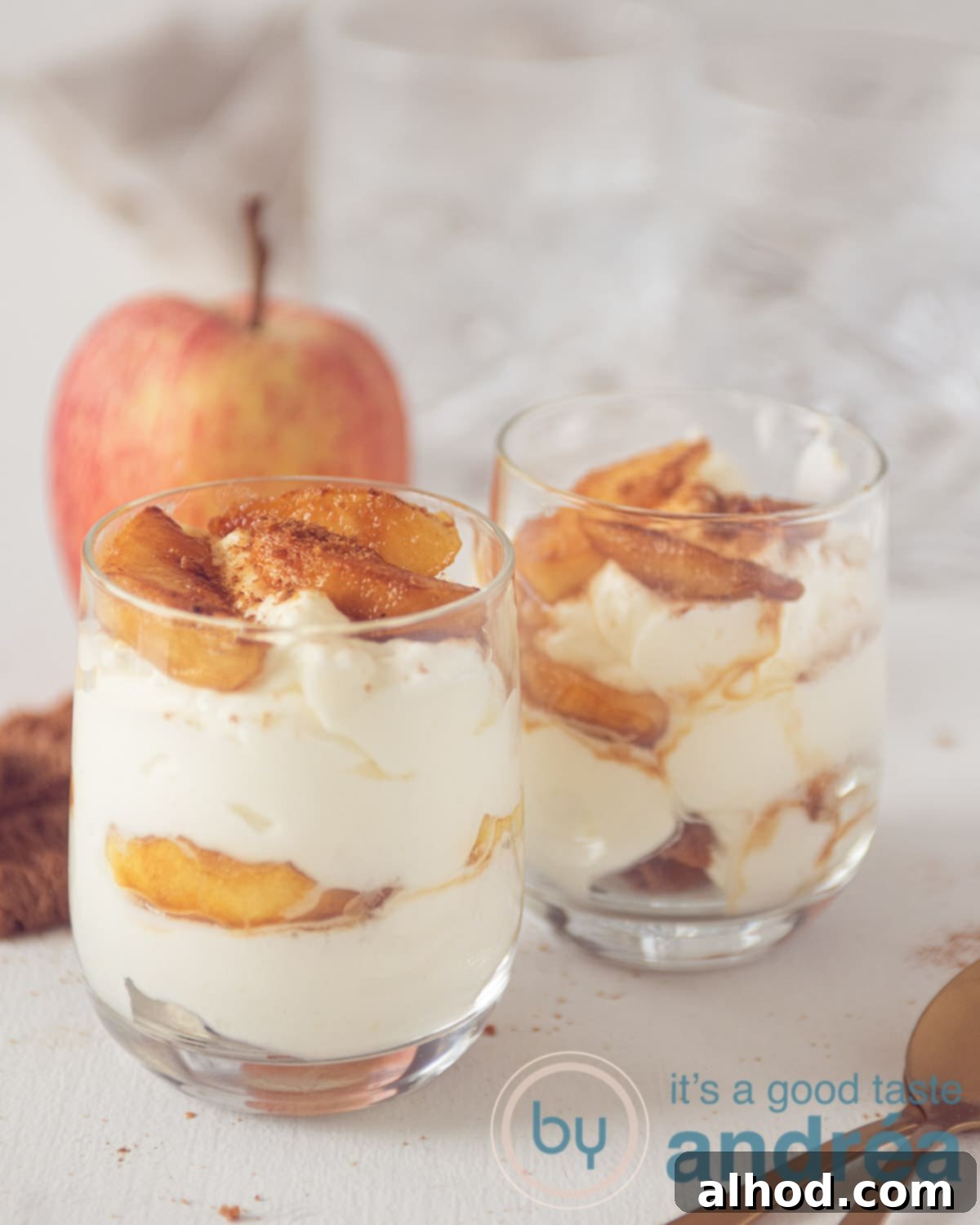 Apple Pie Jars 9 Two glasses with delicious apple pie in a jar on a rustic wooden plate, showcasing the beautiful layers.