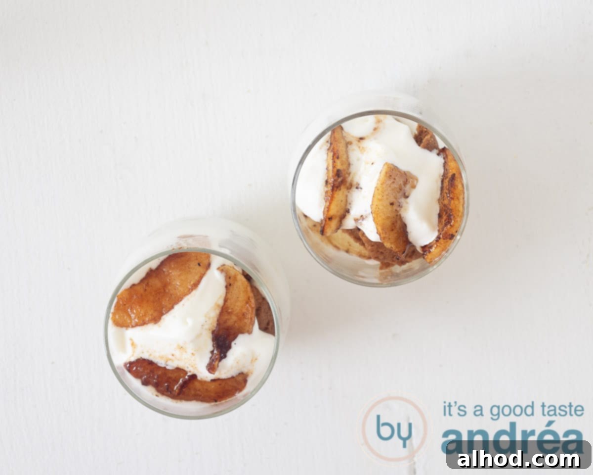 Apple Pie Jars 7 Two glasses filled with layered cookies, vanilla whipped cream, and caramelized baked apples, ready to be served.