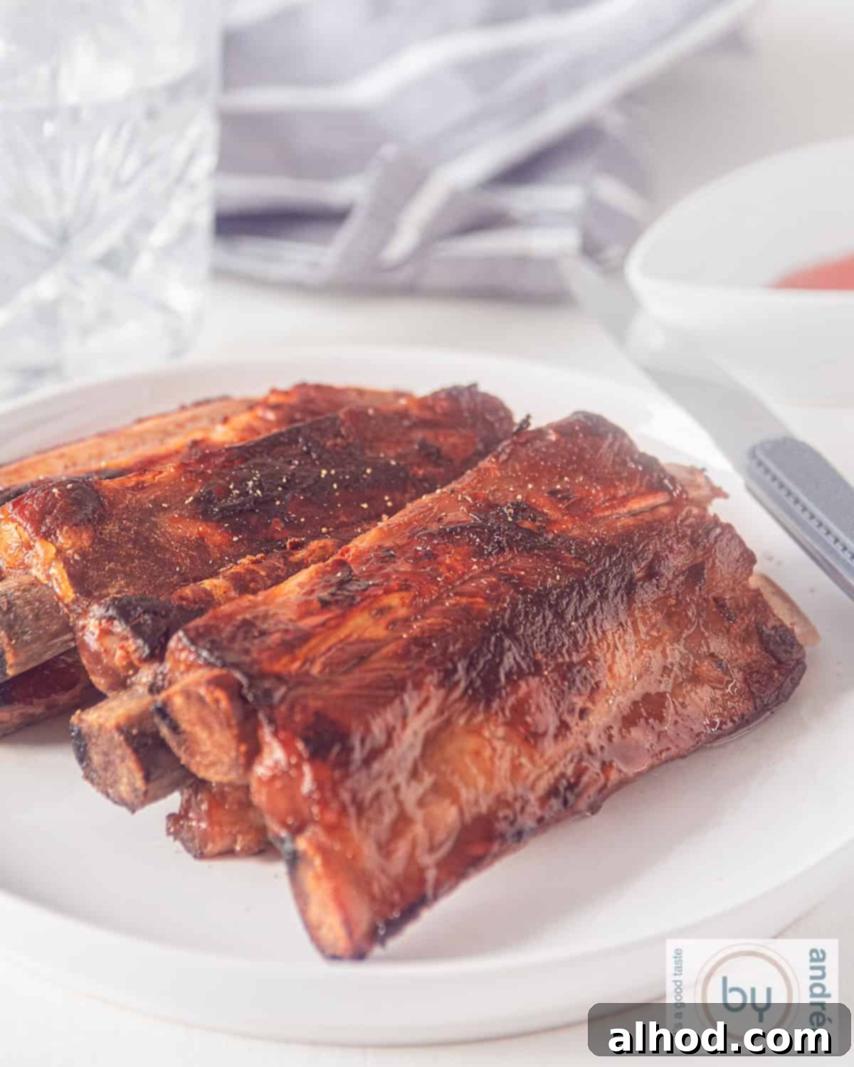 Caramelized Bourbon Soy Ribs 2 A plate of sticky ribs with honey, soy sauce, ketjap and whisky glaze, garnished and ready to serve.