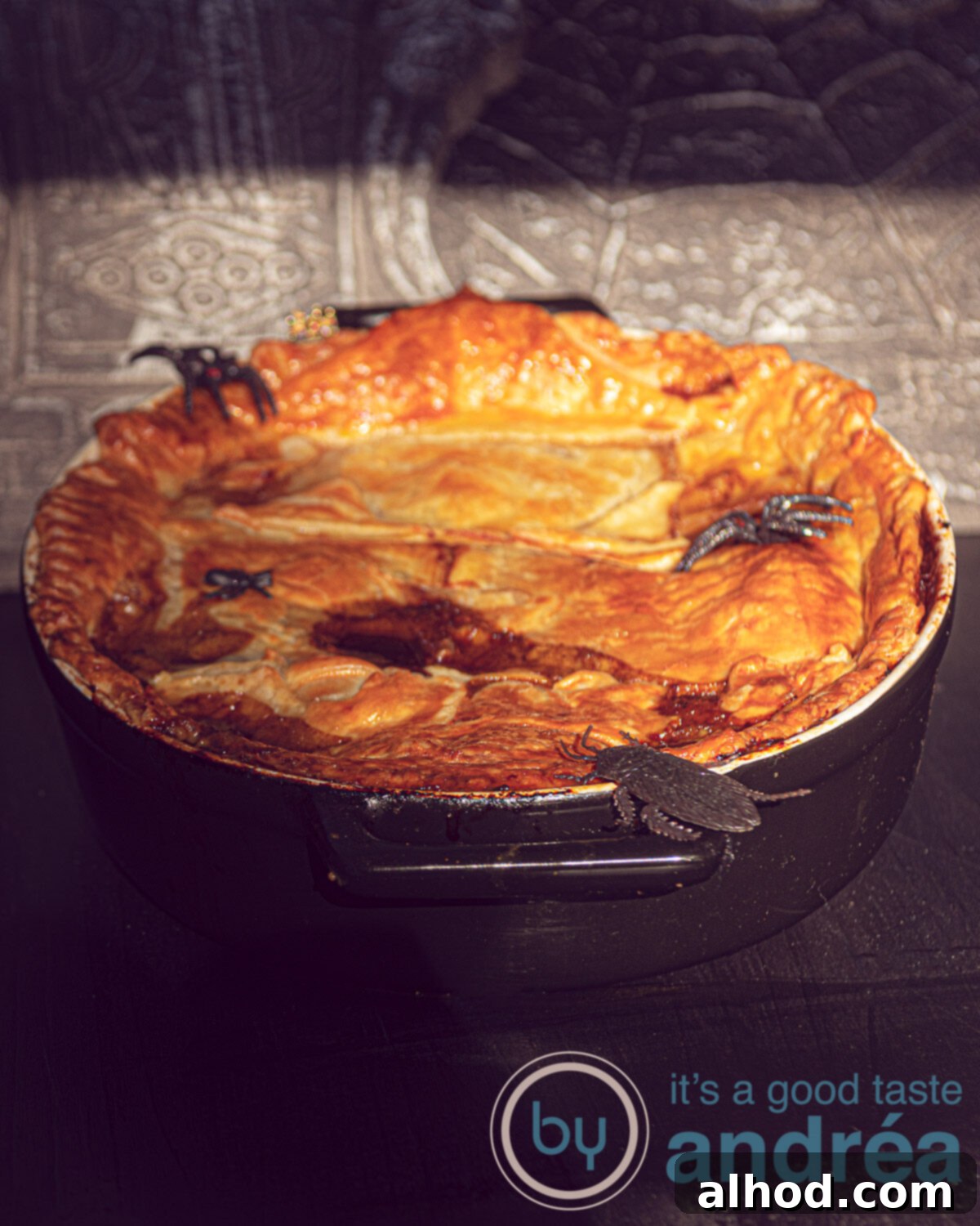Hearty Guinness Steak Pie 2 A black casserole dish topped with puff pastry and filled with Irish stew with Guinness, with halloween decoration