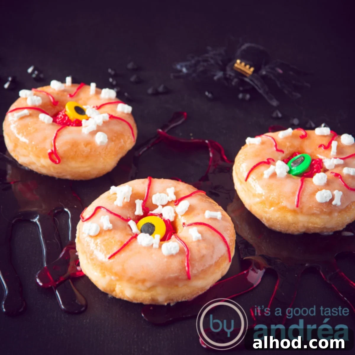Frightfully Delicious Halloween Donuts 4 A square photo of three donuts with an eye decoration. On a black background.