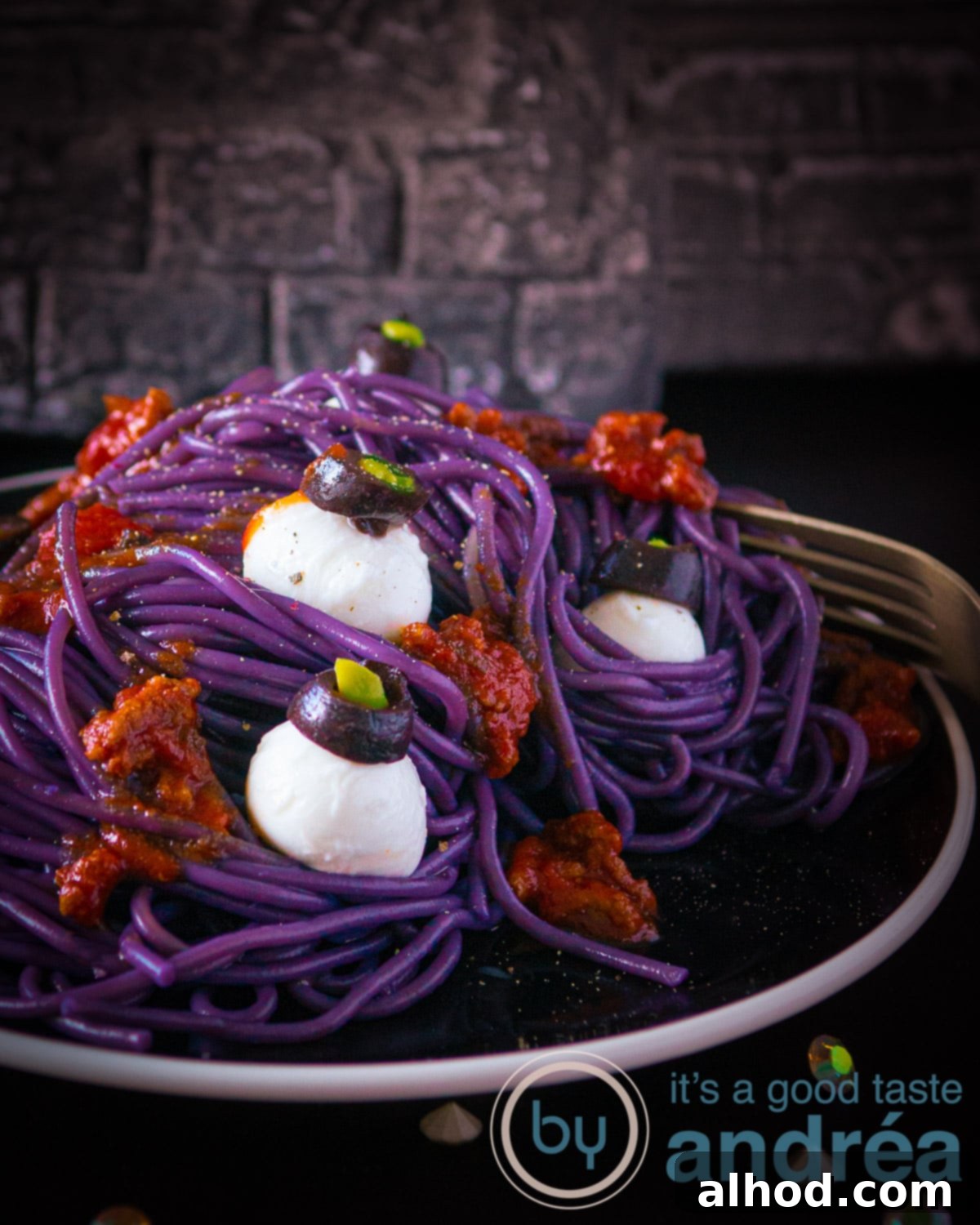 Monster Mash Spaghetti Bolognese 2 A black plate with purple spaghetti bolognaise sauce and mozzarella eye balls