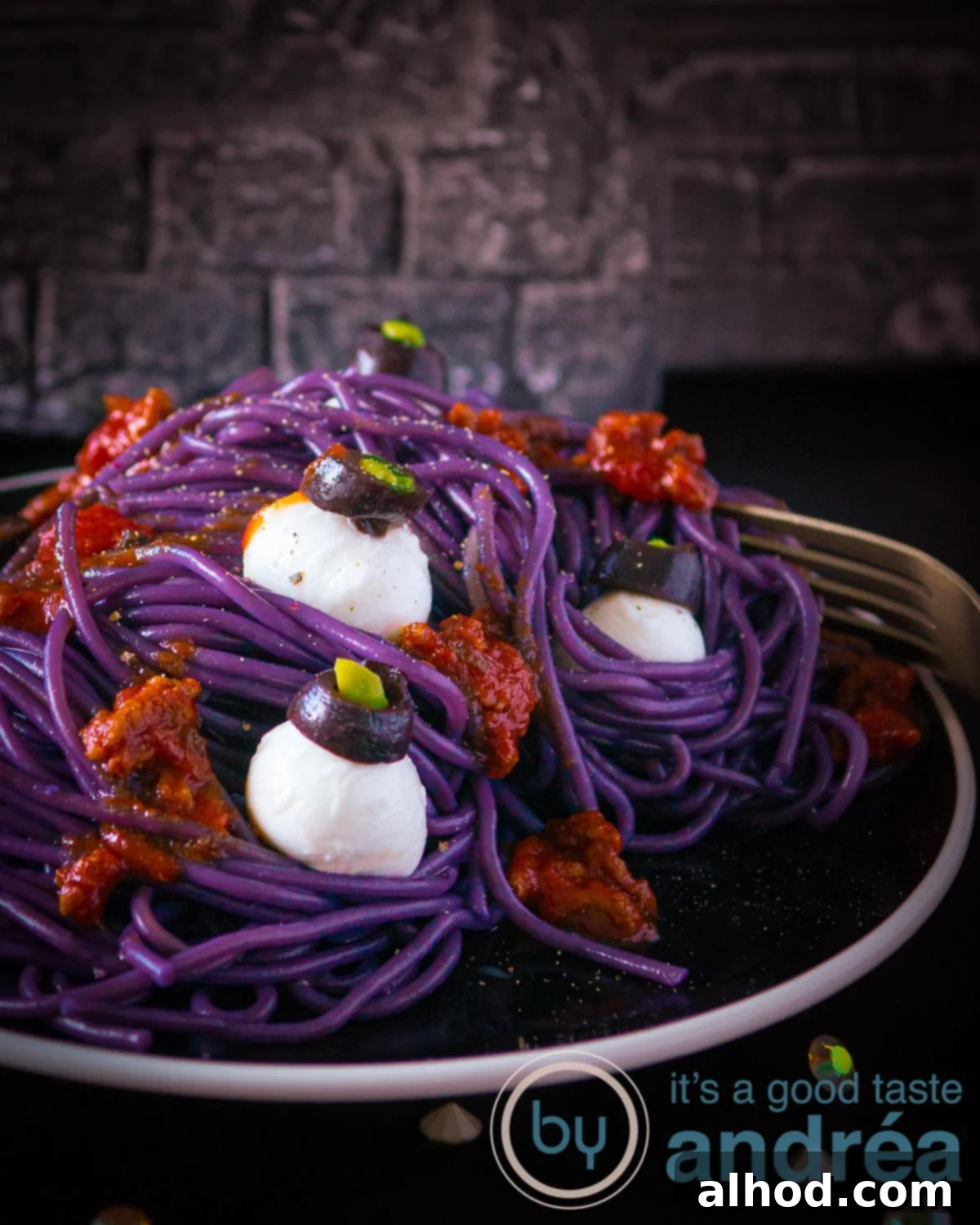 Monster Mash Spaghetti Bolognese 12 A black plate with purple spaghetti bolognaise sauce and mozzarella eye balls