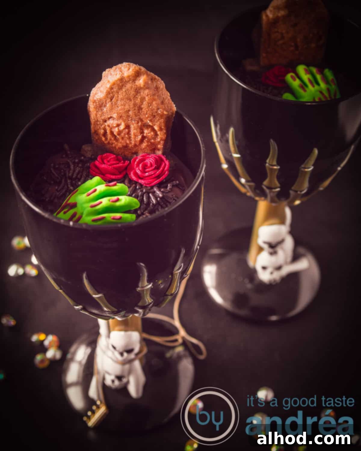 Gingerbread Tombstone Treats 3 A chillingly delightful graveyard dessert served in a black glass, featuring homemade gingerbread cookies as tombstones emerging from chocolate 'dirt.' It's adorned with vibrant sugar roses and a ghoulish zombie hand, all against a dark, mysterious background, perfect for a Halloween party.