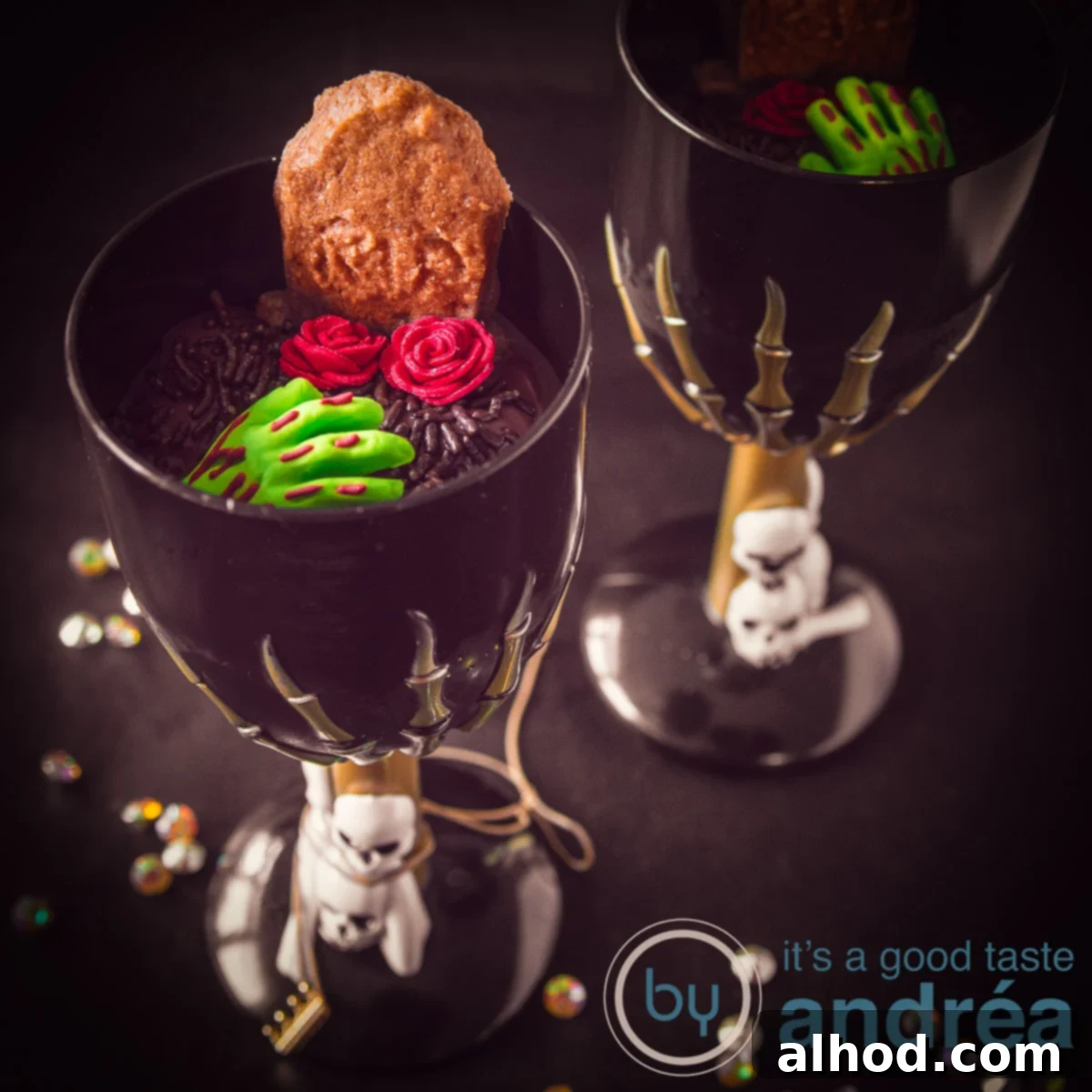 Gingerbread Tombstone Treats 4 A captivating square photo showcasing two black glasses, each filled with rich chocolate mousse 'dirt.' The desserts are dramatically decorated with chilling zombie hands, delicate sugar roses, and homemade gingerbread 'RIP' tombstone cookies, perfect for a Halloween party.