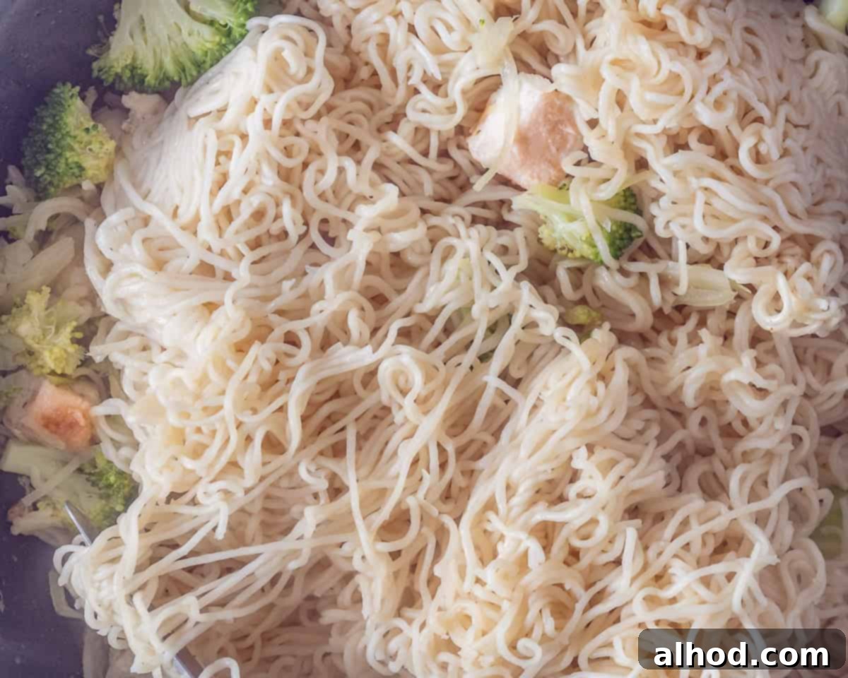 Speedy Chicken Noodle Stir-Fry with Garden-Fresh Veggies 5 A vibrant stir-fry in a wok, showing a harmonious mix of golden-brown chicken pieces, cooked noodles, and colorful vegetables like broccoli and carrots, all simmering in a delicious sauce.